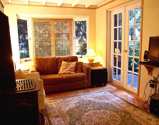 The living room of the Gingerbread cottage in Point Roberts surrounds you in visions of cedars and ferns through antique windows.